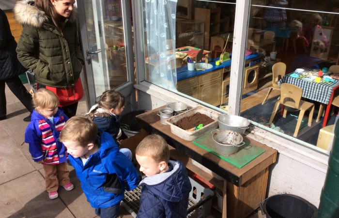 nursery children playing with outdoor kitchen